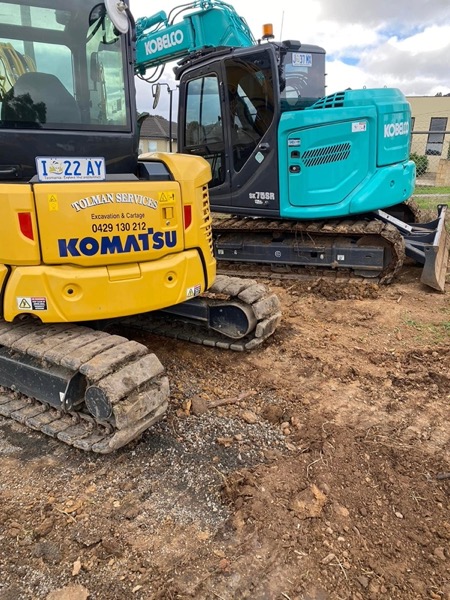 A Tolman Services excavator cab on a rural job